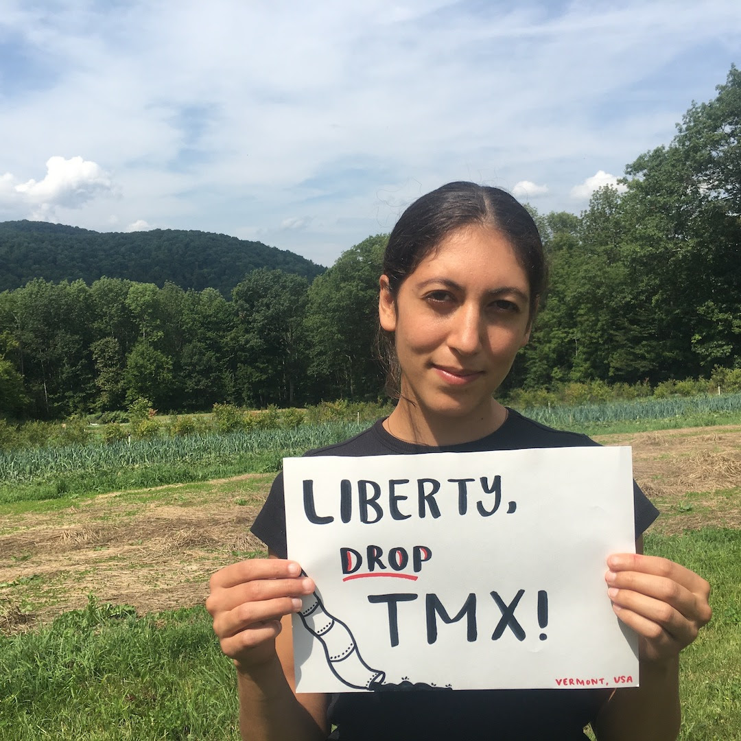 Woman holding sign reading, "Liberty Drop TMX".