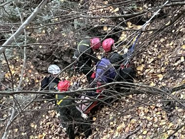 Rangers working on steep hill in the woods to rescue injured hiker