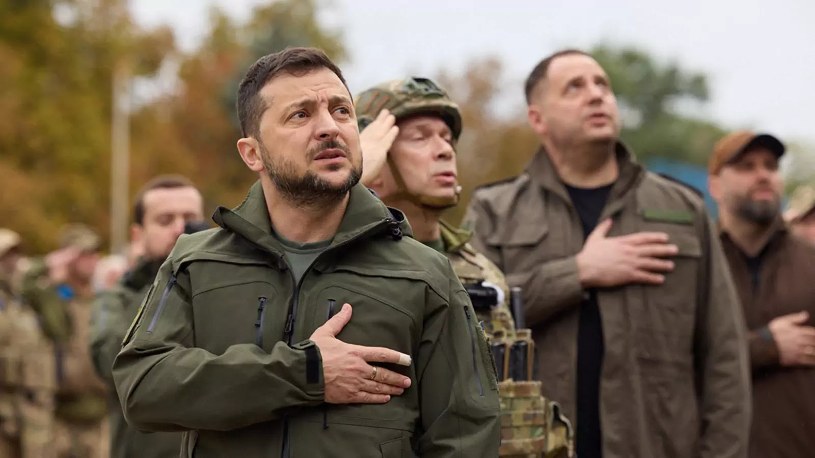 Ukraine’s President Volodymyr Zelensky sings a national anthem on September 14, 2022 during a flag raising ceremony in the recently liberated town of Izium in the Kharkiv region.