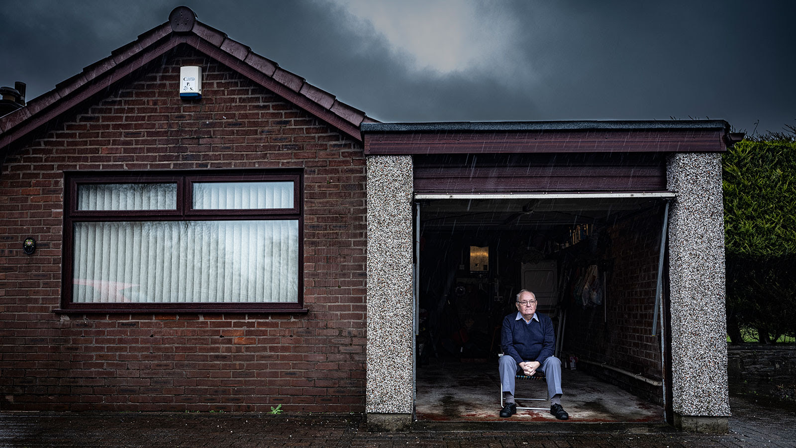 An elderly man sits outside his home in Bolton, where he spent lockdown alone and isolated from friends and family
