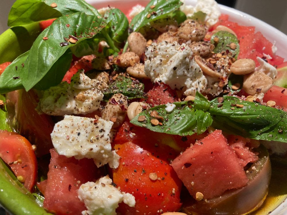 Watermelon and Tomato cubed with chunks of feta and fresh basil leaves. Chopped Almonds and spices mixed with a light vinaigrette 