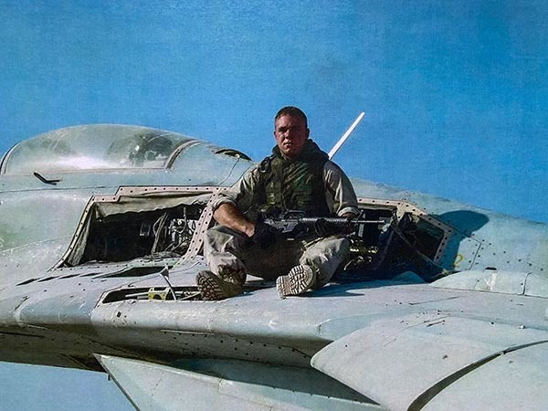 Conservation officer Chris Maher is shown on a military aircraft.
