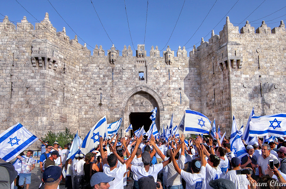 people celebrating with israeli flags at damascus gate in jerusalem