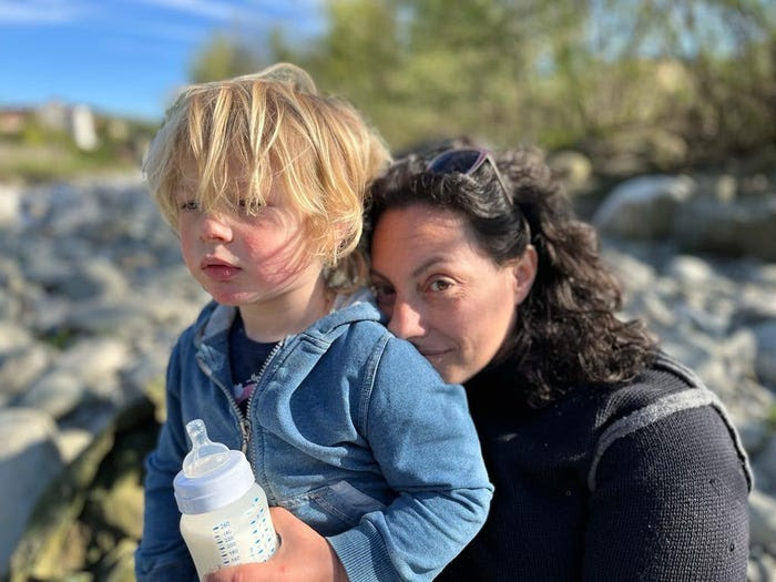 Barnaby Brownsell, who showed signs of puberty at the age of two, is photographed on a beach with his mother, Erica, while holding a baby bottle.