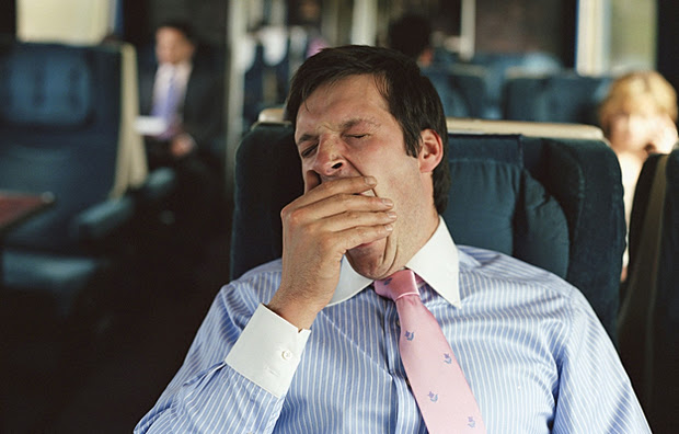 A man yawning on a train.
