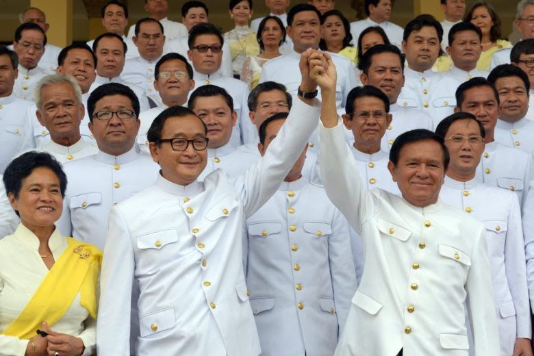Cambodian opposition leader Sam Rainsy (front left) raises hands with Kem Sokha in 2014. Photo: AFP / Tang Chhin Sothy