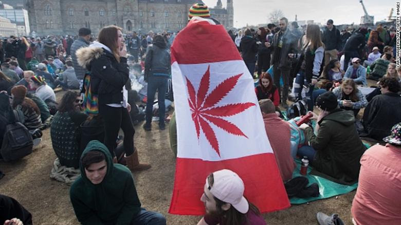 A man wears a Canadian maple leaf flag with marijuana leaf during the annual 4/20 rally on Parliament Hill in Ottawa on April 20, 2018. (Photo by Lars Hagberg / AFP) (Photo credit should read LARS HAGBERG/AFP/Getty Images)