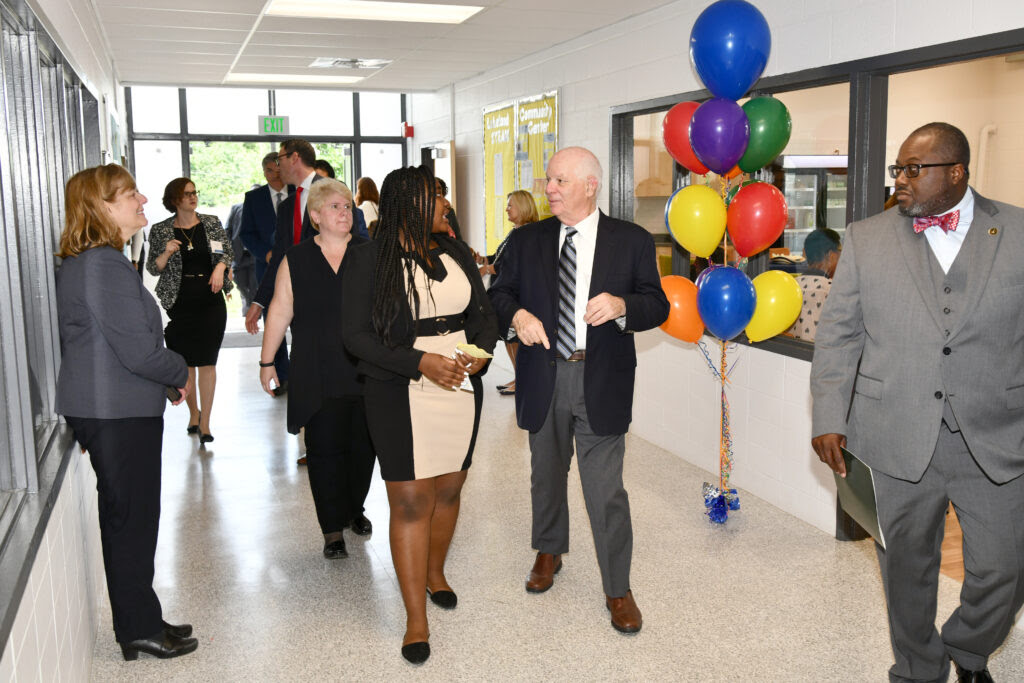 Group takes a tour of a newly renovated building, with balloons decorating the space.