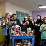 A group of six Edsel Ford High School students show off some of the food collected during the 2019 Battle Against Hunger.