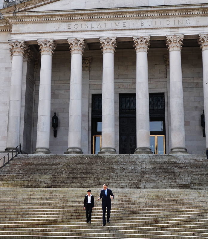 Gov. Jay Inslee walks with state Supreme Court Justice Mary Yu down the steps of the Legislative Building