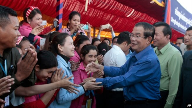 Prime Minister Hun Sen greets garment workers during a visit to a factory outside of Phnom Penh, Cambodia, Wednesday, Aug. 30, 2017.