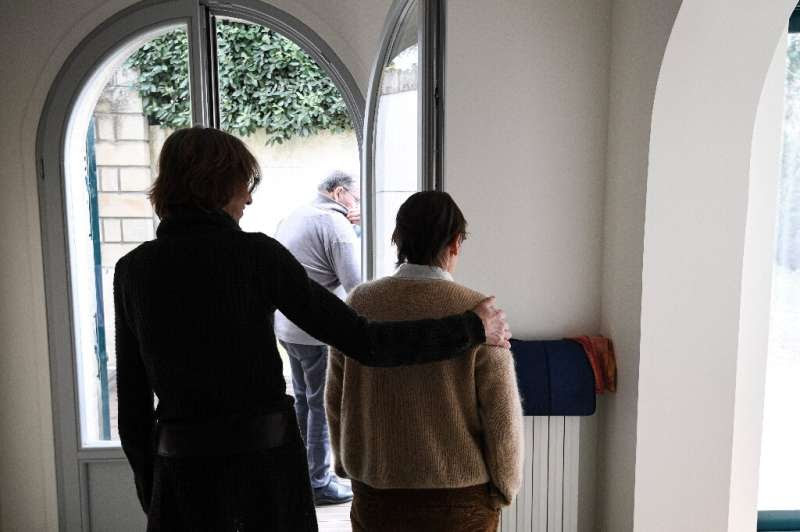 A caretaker helps an elderly resident suffering from Alzheimer's in a home on the outskirts of Paris