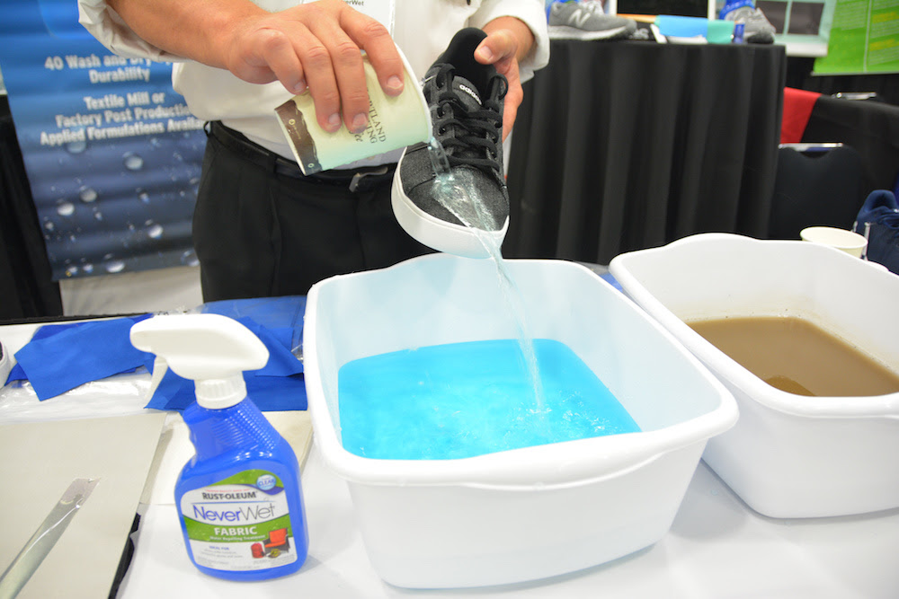 man pouring water on a show over a bucket as the water glides right off