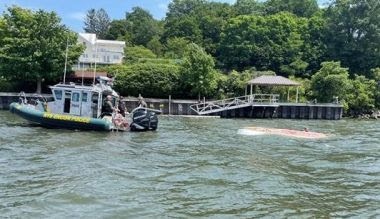 ECO boat towing small capsized boat through the water ECO boat towing small capsized boat through the water