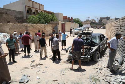 Varias personas revisan el lugar tras el impacto de unas granadas en Trípoli.
