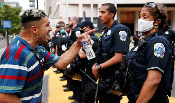 A man yells at a Metropolitan Police officer as demonstrators protest in front of a police line on the section of 16th Street renamed Black Lives Matter Plaza, Tuesday, June 23, 2020, in Washington, over the death of George Floyd, a black man who was in police custody in Minneapolis. Floyd died after being restrained by Minneapolis police officers. (AP Photo/Jacquelyn Martin)