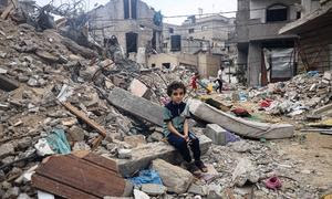 Un niño de ocho años de la ciudad palestina de Rafah sentado en las ruinas de su casa bombardeada por Israel.