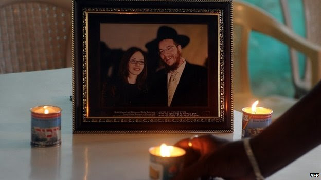 A member of staff places a traditional Jewish Memorial candle in front of a photograph of slain Rabbi Gavriel Holtzberg and his wife Rivkah,at the Jewish cultural centre in Mumbai, November 2012