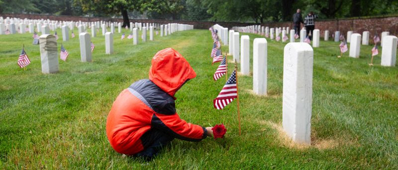 Placing flowers in the rain at Alexandria National Cemetery