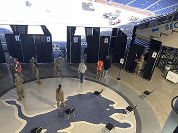 People go into booths to be vaccinated at Ford Field in Detroit