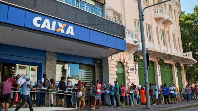 Pessoas fazem fila para coletar auxílio emergencial em meio à pandemia de coronavírus