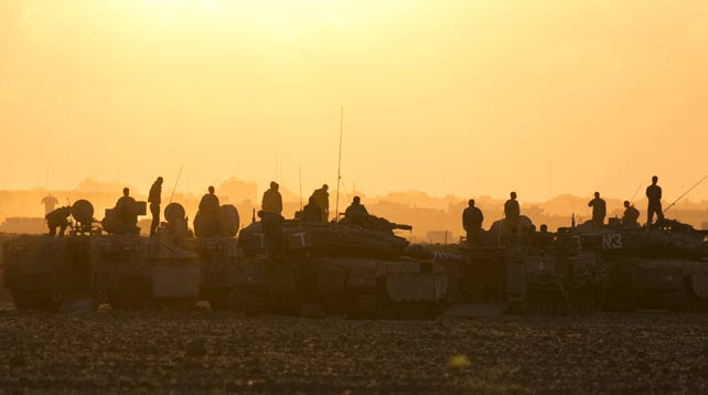Los soldados israelíes permanecen sobre los tanques y transportes blindados en el norte de la Franja de Gaza.