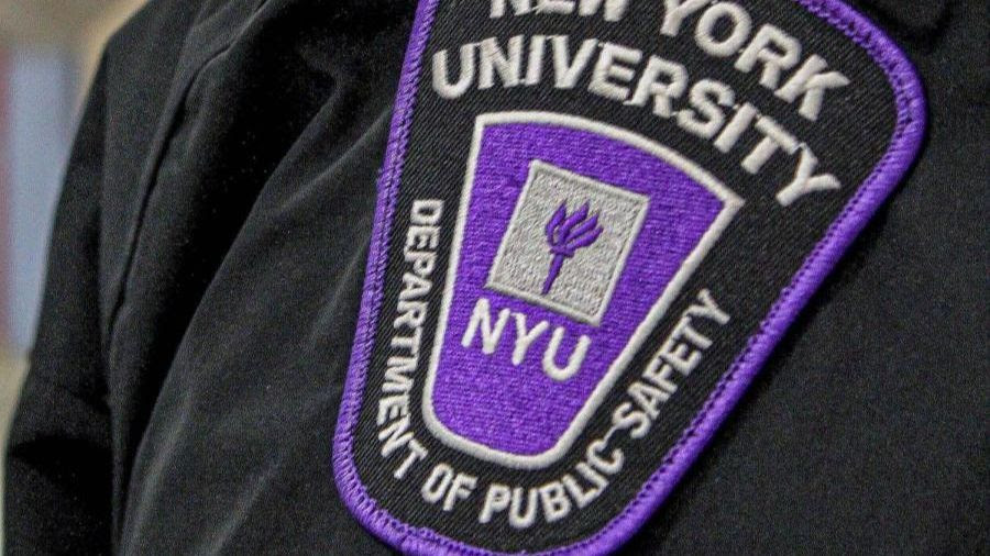 A purple stripe on a uniform with the logo of the Department of Public Safety of New York University on the shoulder of a public safety officer.