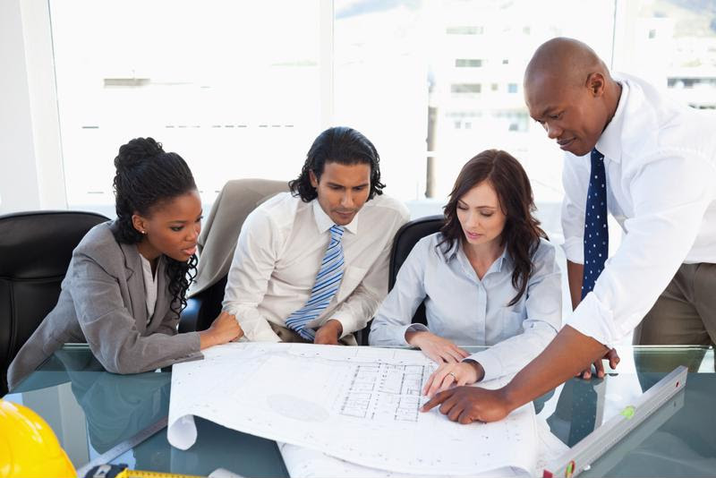Employees study a prined plan.