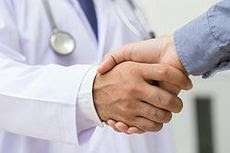 photo of two people shaking hands, one has a stethoscope around their neck