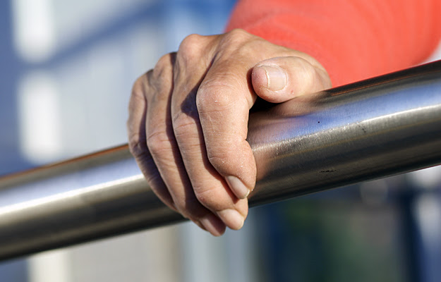 A hand holding on to a handrail.