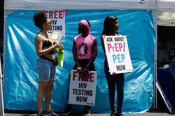 Los voluntarios sostuvieron carteles para promover la prueba gratuita de VIH durante el Desfile del Orgullo de Harlem en junio.