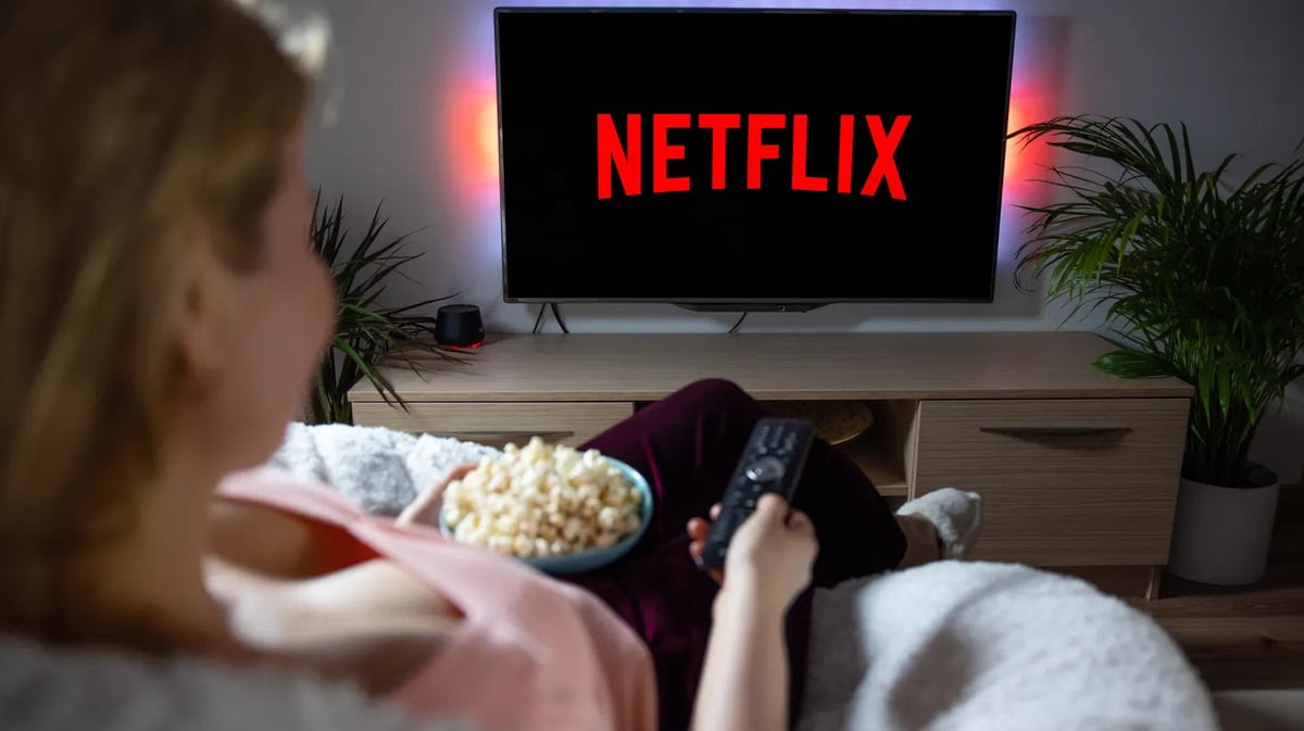 Woman accesses Netflix on a television set. Photo by Kaspars Grinvalds/Shutterstock