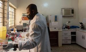 Un médico revisando una muestra en el laboratorio de microbiología de un hospital universitario de Nigeria.