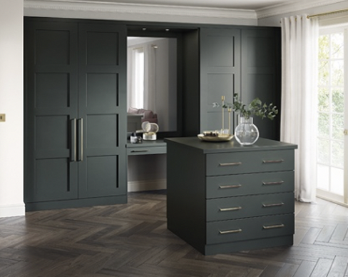 a dark green dressing room with shaker panelling and pull handles