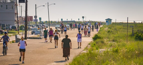 People walking on a path next to a beach
