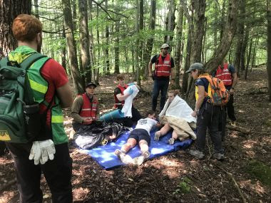 Rangers and civilians participate in disaster response training in the woods
