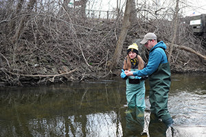A citizen science volunteer learns the eDNA sampling protocol on Paint Creek.