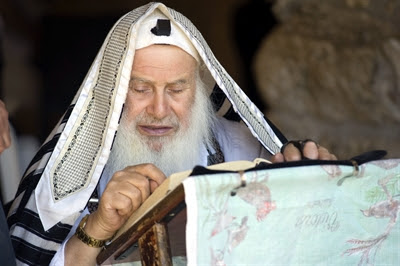 A Jewish man
                    wearing a tallit (prayer shawl) and tefillin
                    (phylacteries) prays at the Western (Wailing) Wall
                    in Jerusalem.