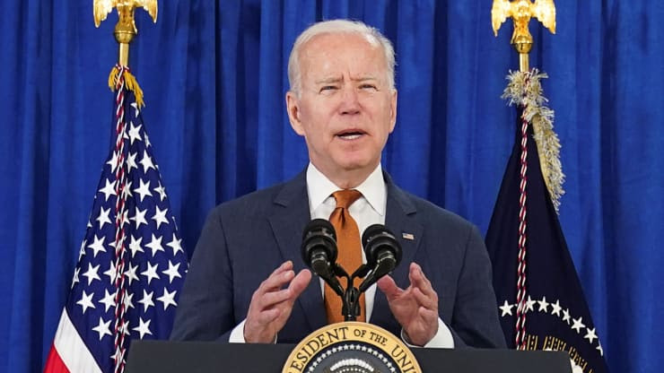 President Biden gestures behind a podium 