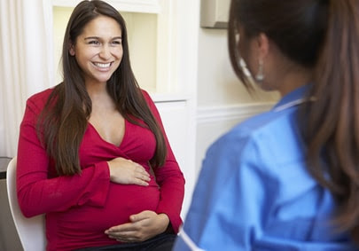 pregnant woman smiling at healthcare provider