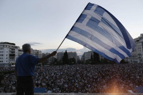 Un manifestante ondea una bandera griega, a las afueras del Parlamento...