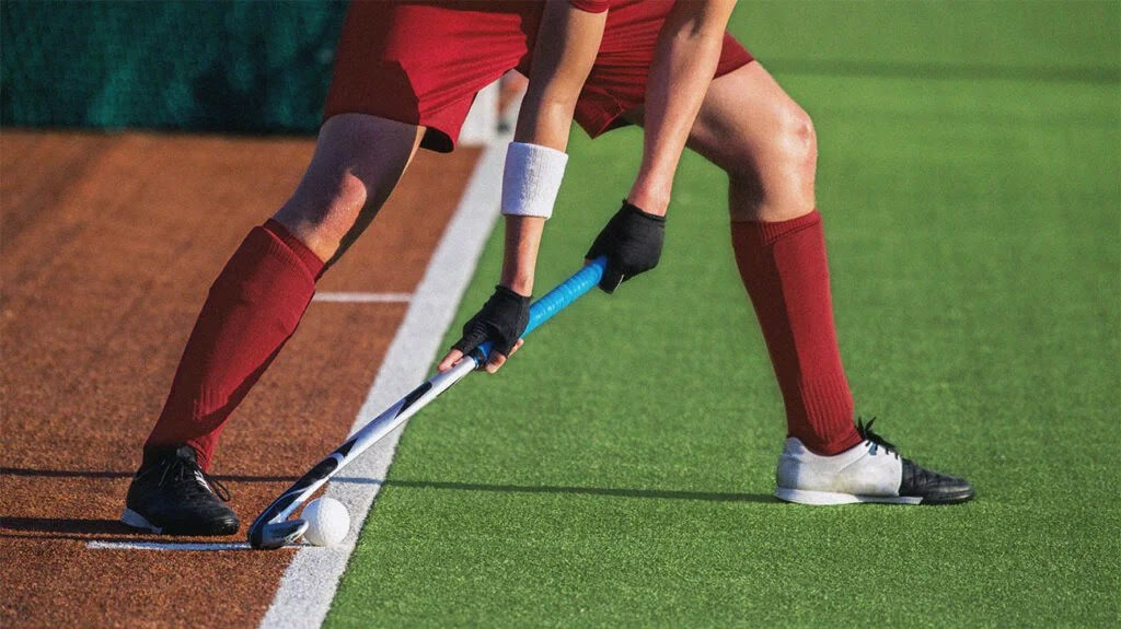 A person playing hockey, who may be at a higher risk for a sports hernia.