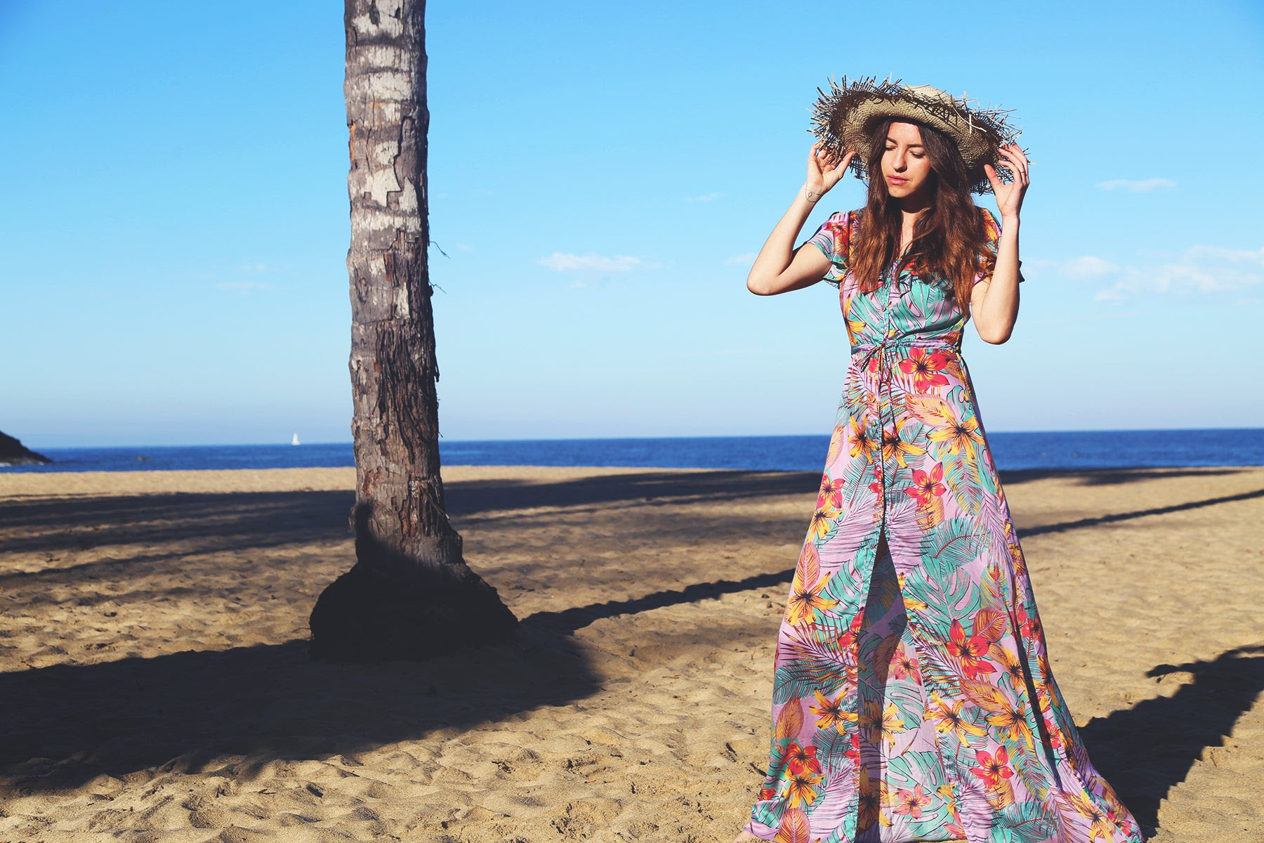 A colour dress being modelled by Yana Dales, founder of TAMGA Designs on a beach.