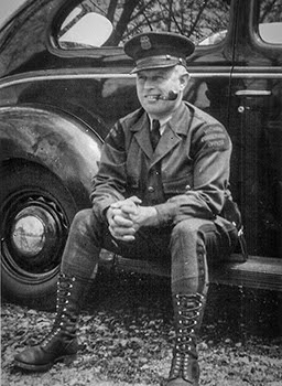 A photo of Conservation Officer Mellon shows him with his patrol vehicle.