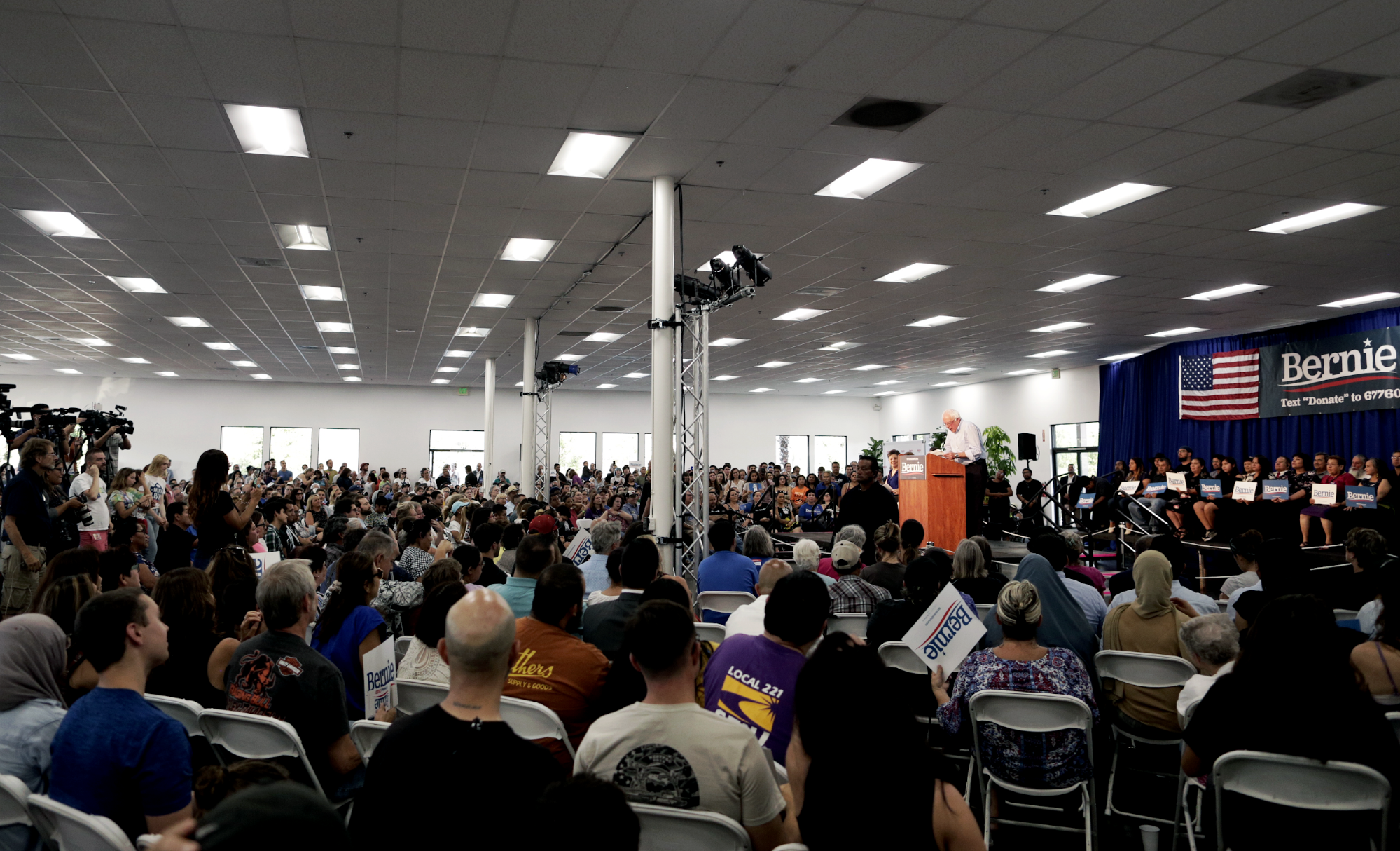 View from large crowd of Bernie speaking on stage at immigration town hall in Vista, CA