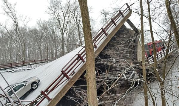 Vehicles that were on a bridge when it collapsed are visible, Friday Jan. 28, 2022, in Pittsburgh&#39;s East End. The bridge spanning a ravine collapsed in Pittsburgh, requiring rescuers to rappel nearly 150 feet while others formed a human chain to help rescue multiple people from a dangling bus. The collapse early Friday came hours before President Joe Biden was to visit the city to press for his $1 trillion infrastructure bill, which includes bridge maintenance. (Jason Cato/Pittsburgh Tribune-Review via AP)