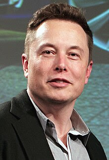 A close-up of Musk's face while giving a talk