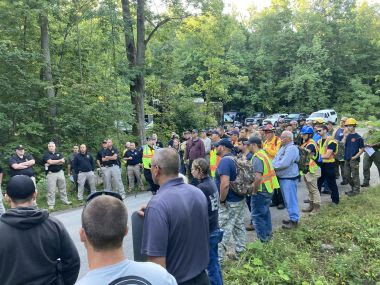 Forest Rangers and volunteers wearing reflective vests help with recovery mission