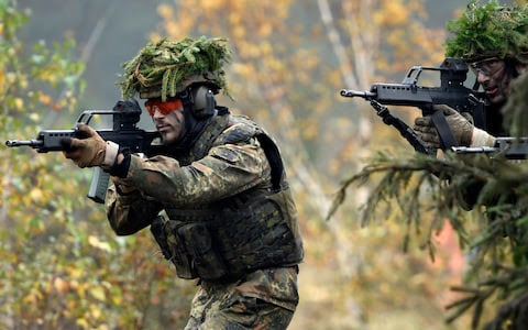 Armored infantryman of the Bundeswehr, the German armed forces, during a simulated attack as part of military exercises  