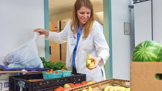 Dietitian Anna Ziegler selects fresh produce for a Fresh Food Farmacy patient.